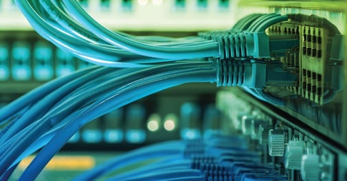 Imagen de primer plano de un conmutador de red con múltiples cables que conectan diferentes dispositivos, como computadoras, servidores y equipos de red.