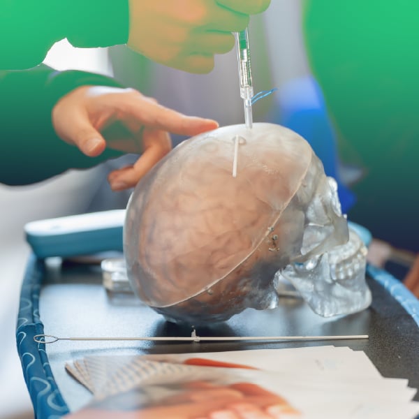 Photo of health professional demonstrating insertion of Kitea product into prop head.