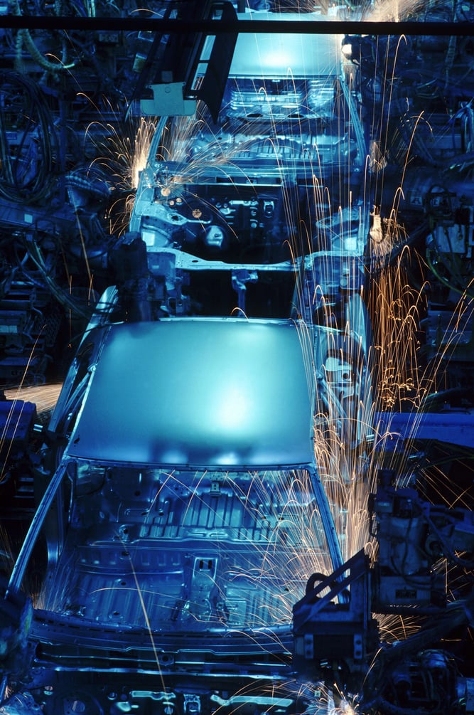 Graphic showing automated robots in an automotive assembly line.