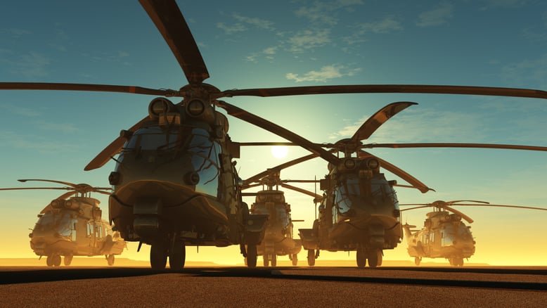 Image showing a lineup of 5 DO-178C compliant military helicopters at dusk