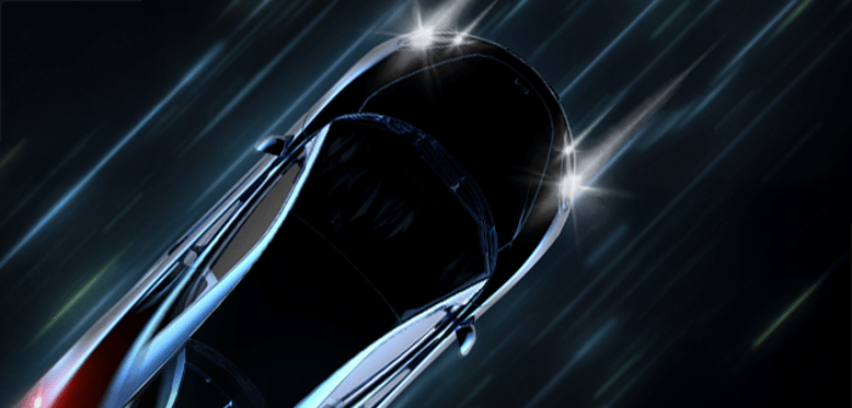 Overhead view of a black car driving down a dark street. Car has lights on.